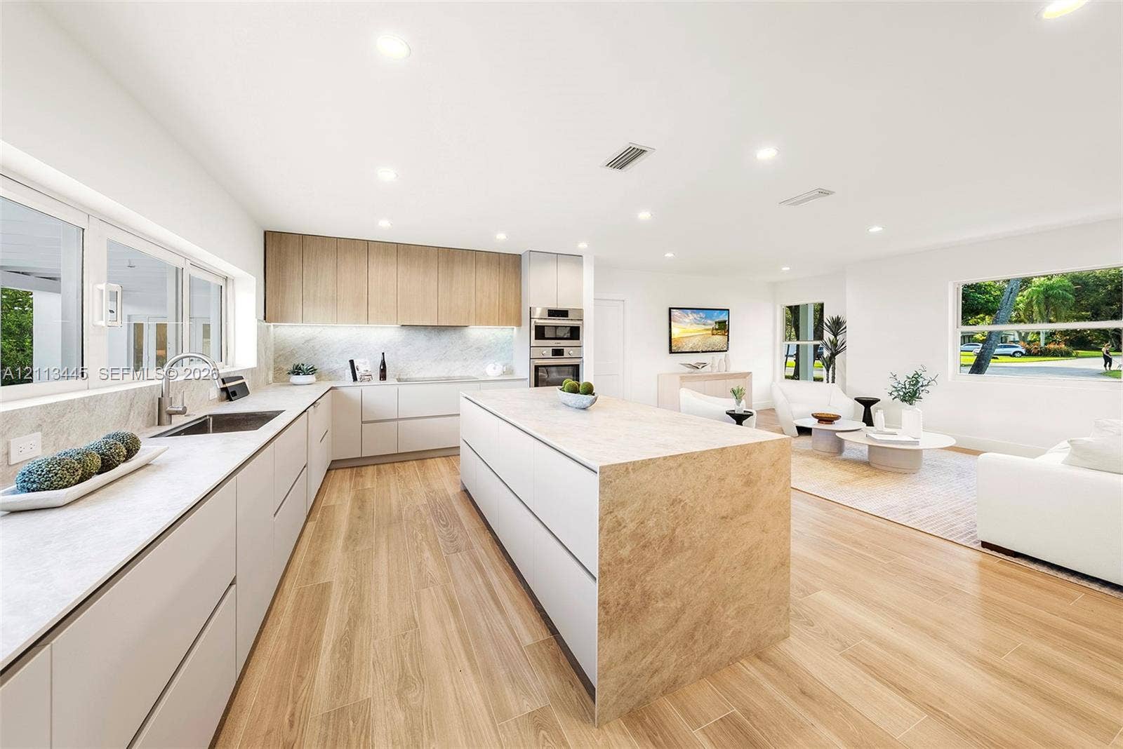 6951 SW 134th Street, Pinecrest, Pinecrest, FL 33156 Kitchen featuring flat-panel cabinetry, a central island with stone-finish surfaces, integrated stainless steel double wall ovens, recessed lighting, and wood-finish flooring