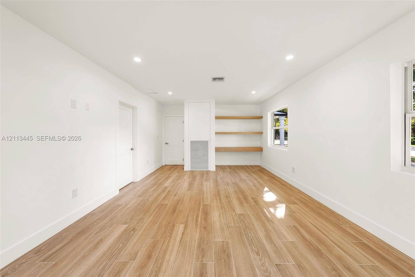 6951 SW 134th Street, Pinecrest, Pinecrest, FL 33156 Neutral interior space featuring wood-finish flooring, recessed lighting, and built-in wall shelving