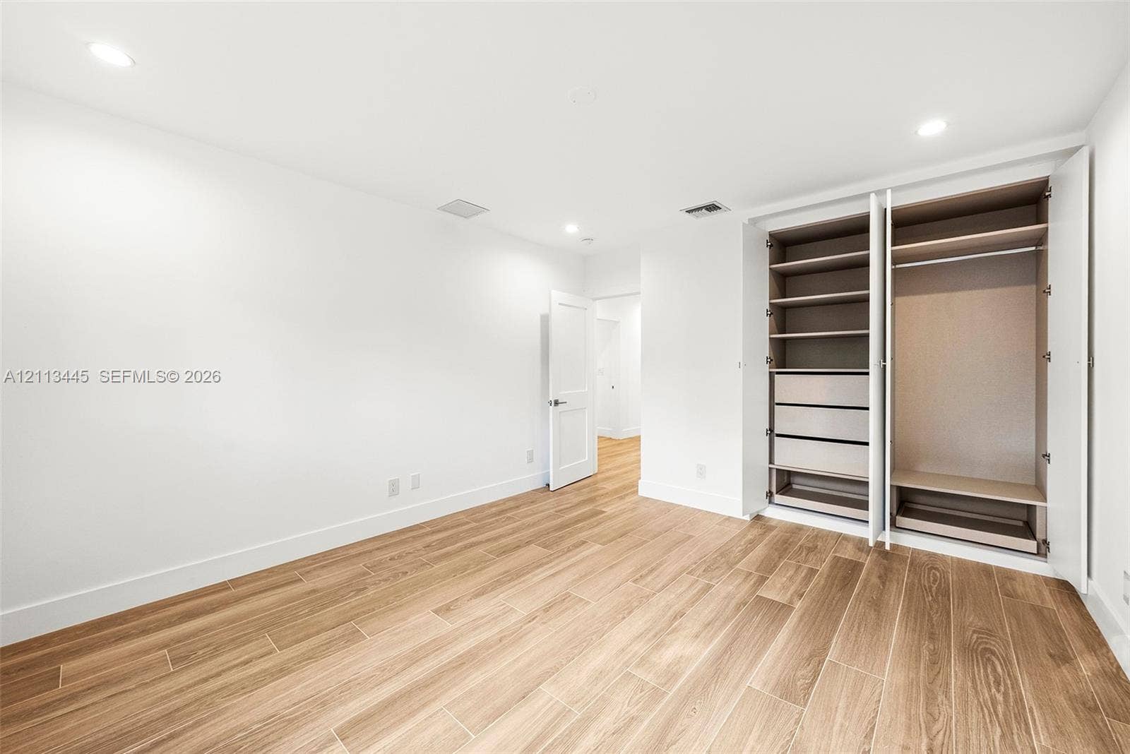 6951 SW 134th Street, Pinecrest, Pinecrest, FL 33156 Wood-finish flooring, recessed lighting, and built-in cabinetry featuring integrated shelving and drawers