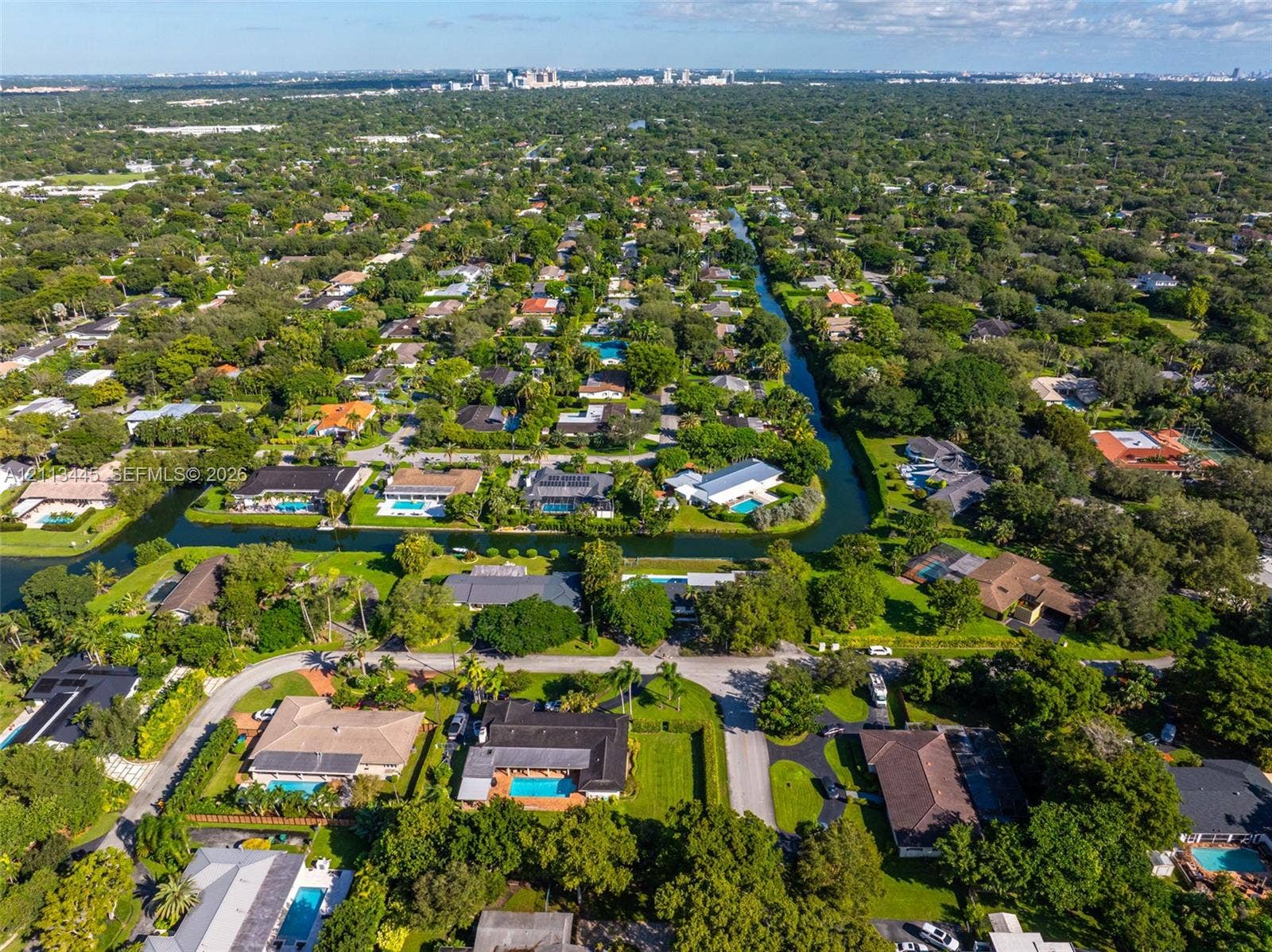 6951 SW 134th Street, Pinecrest, Pinecrest, FL 33156 Aerial perspective featuring residential lots with canal frontage, mature trees, and dense foliage within a suburban setting