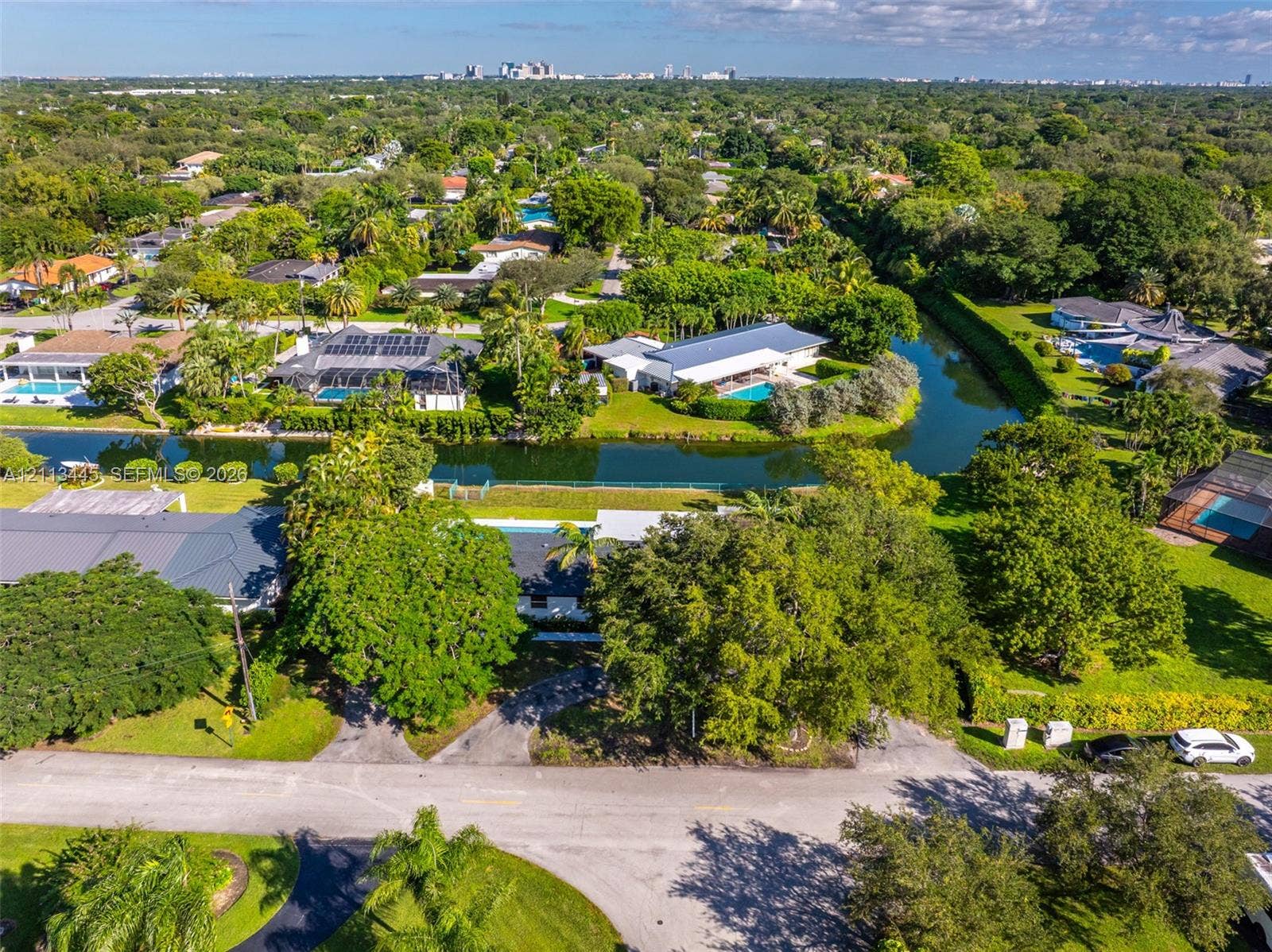 6951 SW 134th Street, Pinecrest, Pinecrest, FL 33156 Aerial perspective featuring a waterfront property with a private swimming pool, mature tree canopy, and direct waterway access