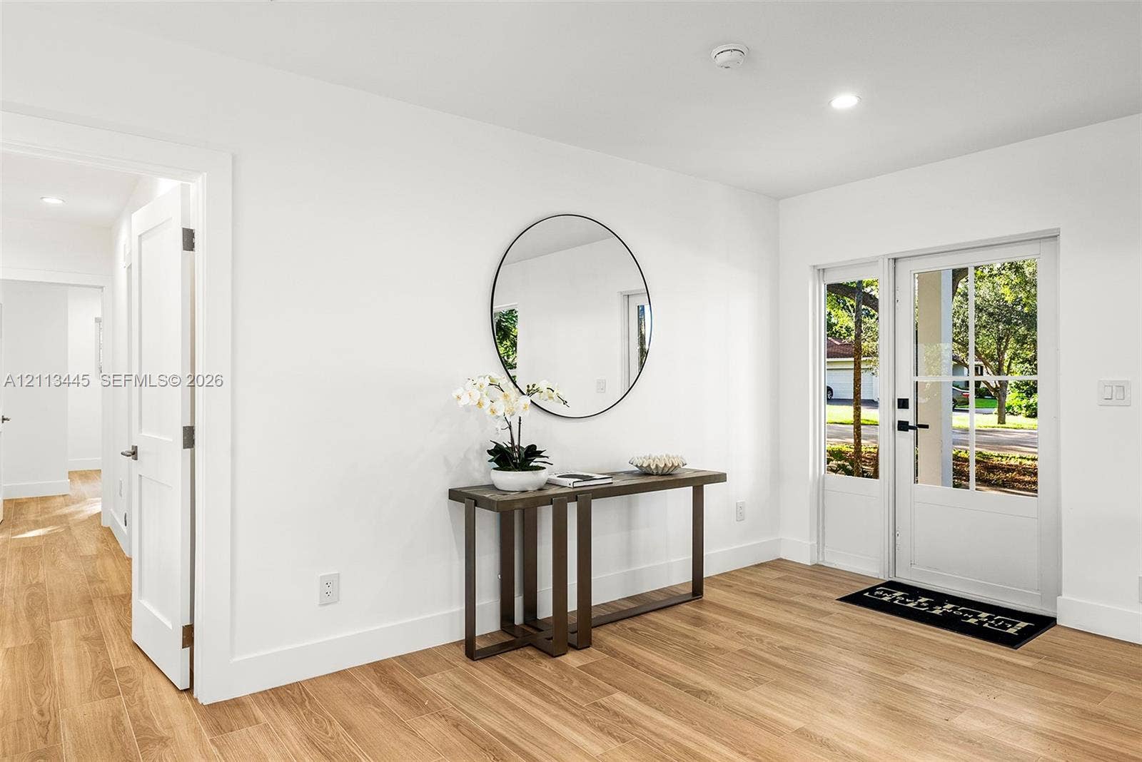 6951 SW 134th Street, Pinecrest, Pinecrest, FL 33156 Entryway featuring light wood-finish flooring, recessed lighting, and a white exterior door with glass panels and a sidelight