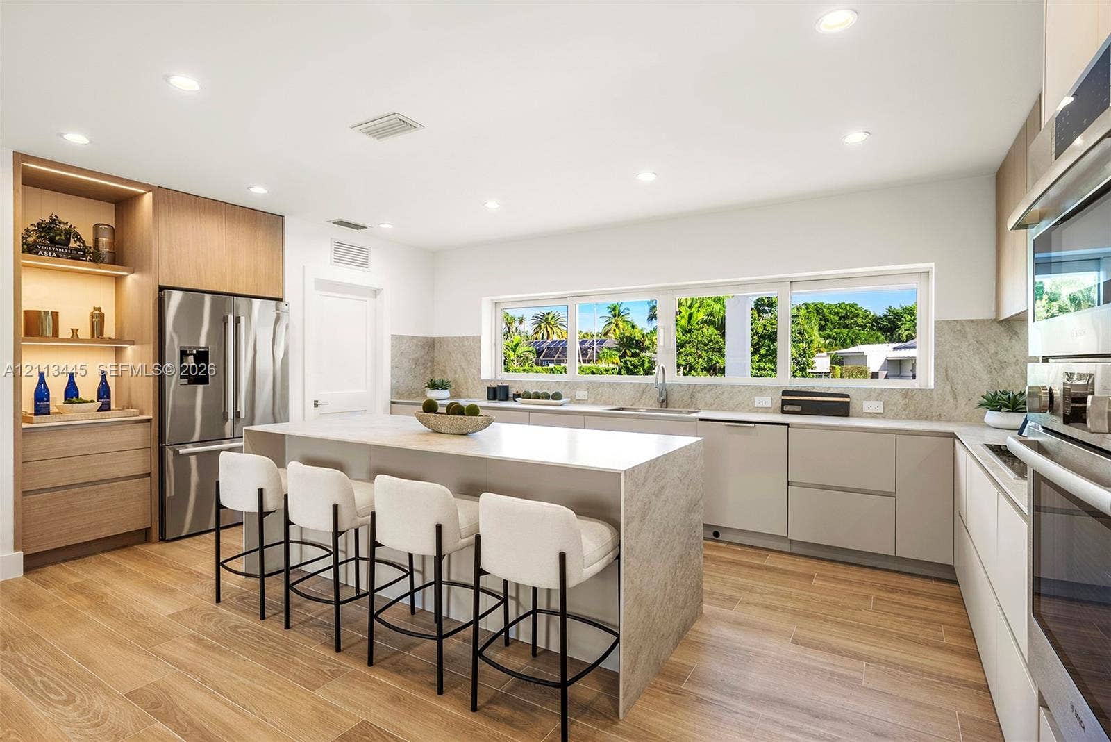 6951 SW 134th Street, Pinecrest, Pinecrest, FL 33156 Kitchen featuring flat-panel cabinetry, a central island with a stone-finish countertop, wood-finish flooring, recessed lighting, and stainless steel built-in appliances