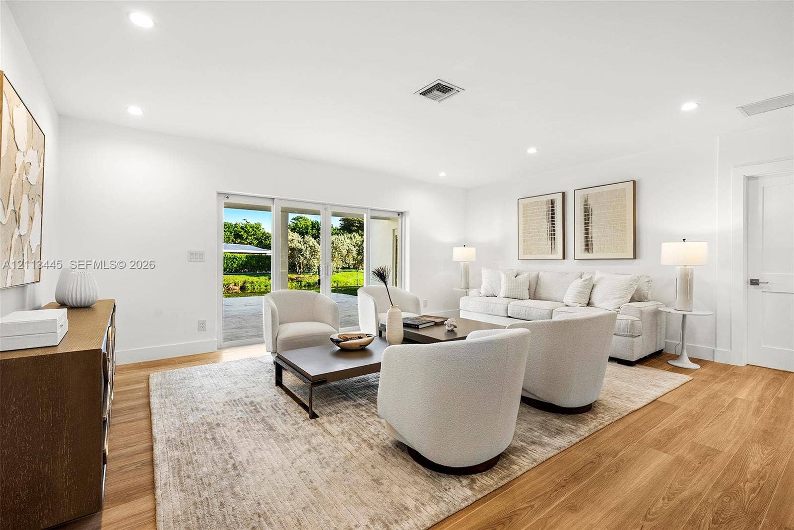 6951 SW 134th Street, Pinecrest, Pinecrest, FL 33156 Living area featuring wood-finish flooring, recessed lighting, and large sliding glass doors providing outdoor access