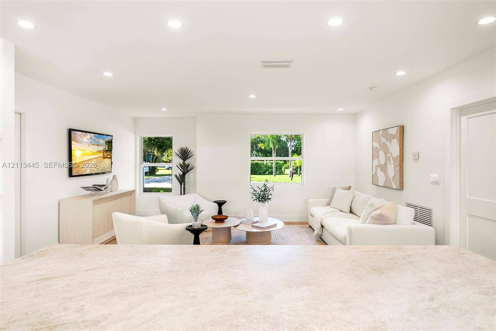 6951 SW 134th Street, Pinecrest, Pinecrest, FL 33156 Neutral-toned countertop with integrated breakfast bar, recessed lighting, and dual windows