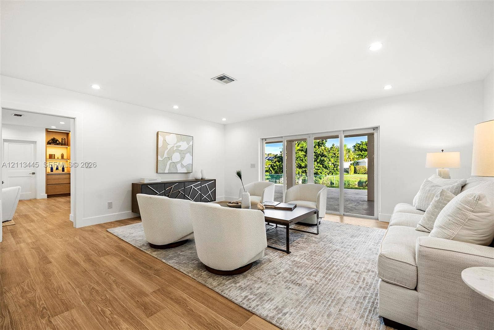 6951 SW 134th Street, Pinecrest, Pinecrest, FL 33156 Living area featuring wood-finish flooring, recessed lighting, and expansive glass sliding doors