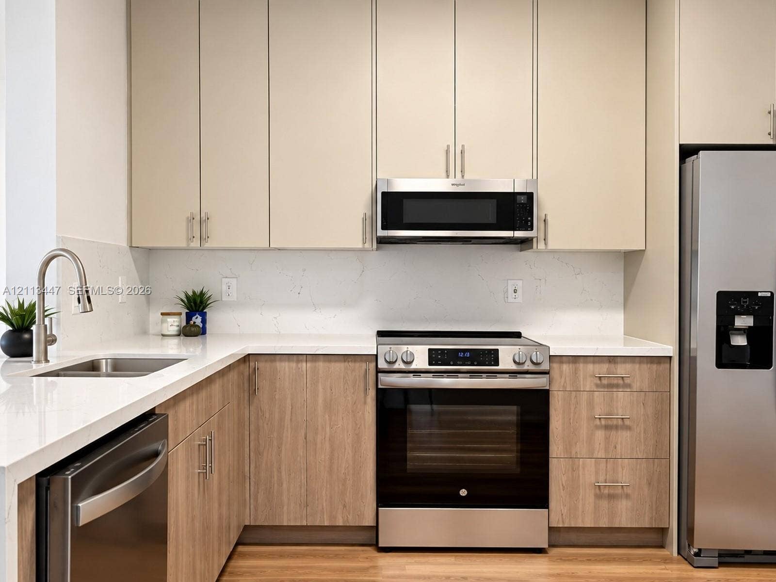 3818 San Simeon Circle, #3818, Weston, Weston, FL 33331 Kitchen featuring flat-panel, luxury laminated flooring, base cabinetry, light-toned upper cabinetry, Carrara quartz countertops with waterfall edge, full-height solid-surface backsplash, and stainless steel appliances
