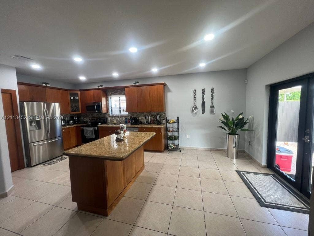 5083 SW 160th Avenue, Miami, Miami, FL 33185 Kitchen featuring wood cabinetry, a central island with stone-finish countertop, recessed lighting, tile flooring, and glass-paneled exterior door
