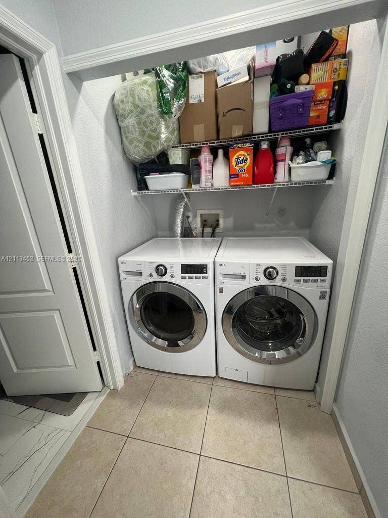 5083 SW 160th Avenue, Miami, Miami, FL 33185 Laundry alcove featuring a pair of front-loading white appliances and built-in wire shelving