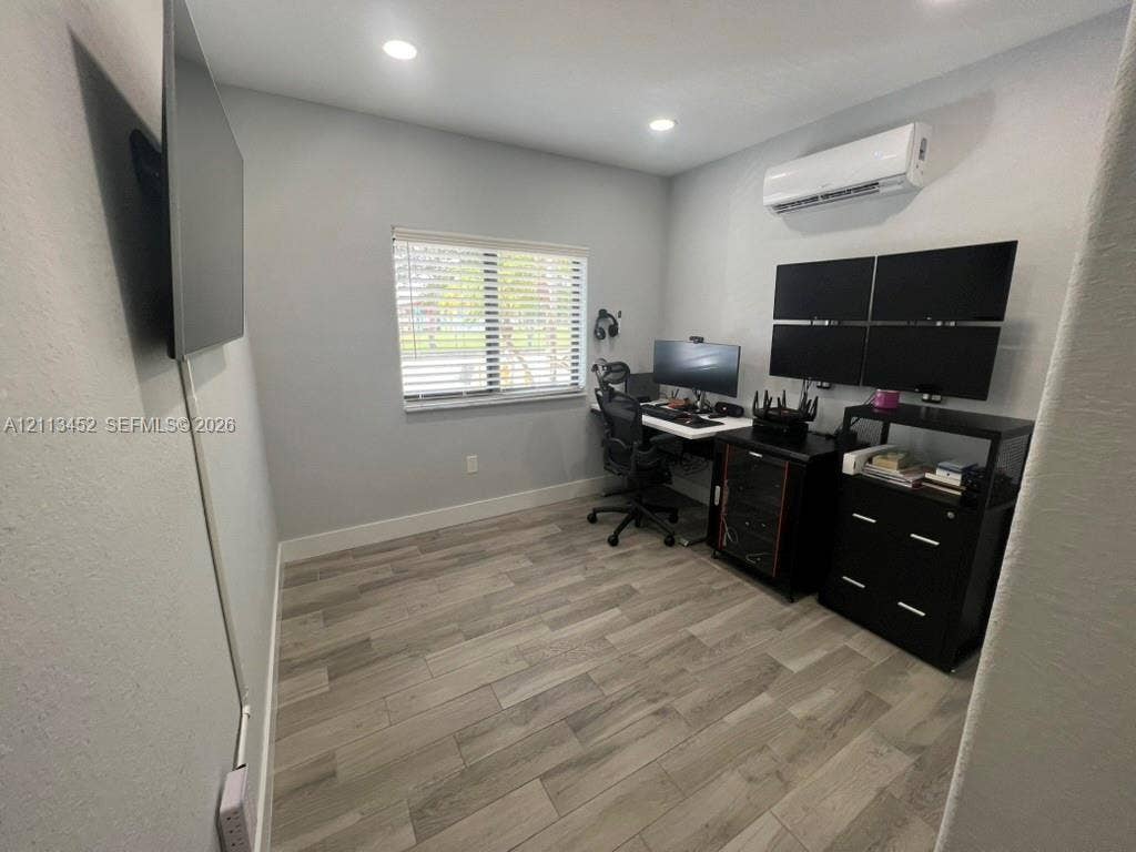 5083 SW 160th Avenue, Miami, Miami, FL 33185 Interior room featuring wood-finish flooring, recessed lighting, a wall-mounted ductless mini-split HVAC unit, and a window with horizontal blinds