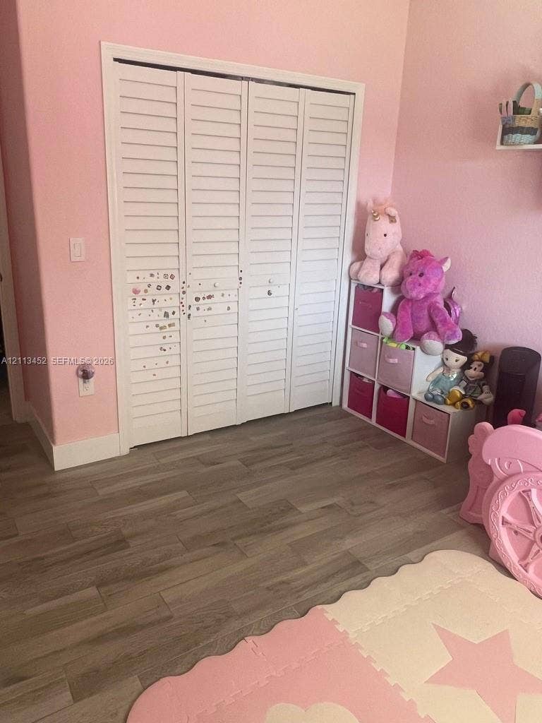 5083 SW 160th Avenue, Miami, Miami, FL 33185 Bi-fold closet doors featuring white louvered panels and wood-finish flooring