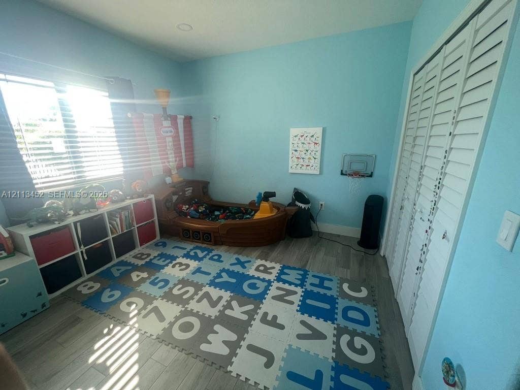 5083 SW 160th Avenue, Miami, Miami, FL 33185 Bedroom featuring wood-finish flooring, recessed lighting, and white louvered-style closet doors
