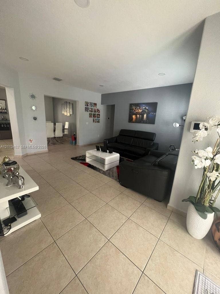 5083 SW 160th Avenue, Miami, Miami, FL 33185 Open-concept interior featuring neutral ceramic tile flooring, recessed lighting, and a charcoal-toned accent wall