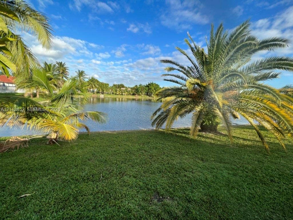 5083 SW 160th Avenue, Miami, Miami, FL 33185 Waterfront grounds featuring mature palm trees, manicured turf, and a natural pond