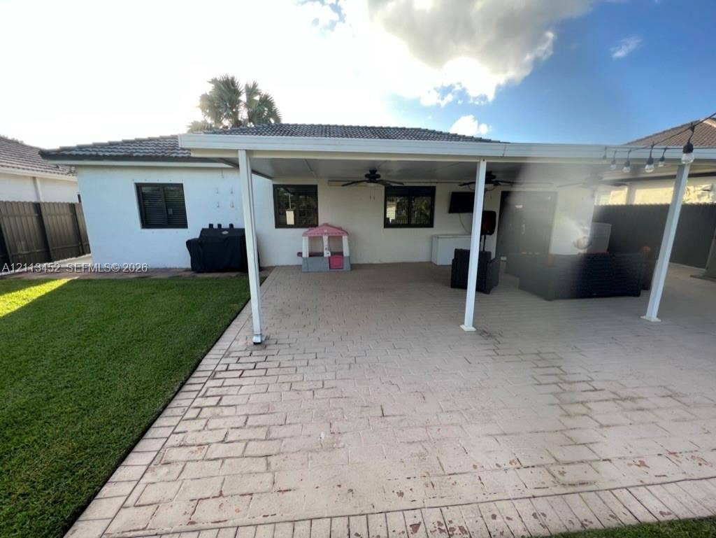 5083 SW 160th Avenue, Miami, Miami, FL 33185 Covered patio featuring paver flooring, ceiling fans, and a spacious backyard with a lawn
