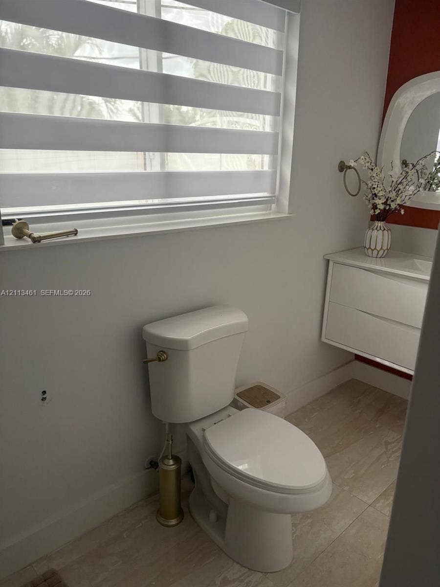 9961 SW 20th Street, Miami, Miami, FL 33165 Floating white vanity with integrated basin, light-toned tiled flooring, adjustable horizontal window shade, and brushed metallic hardware
