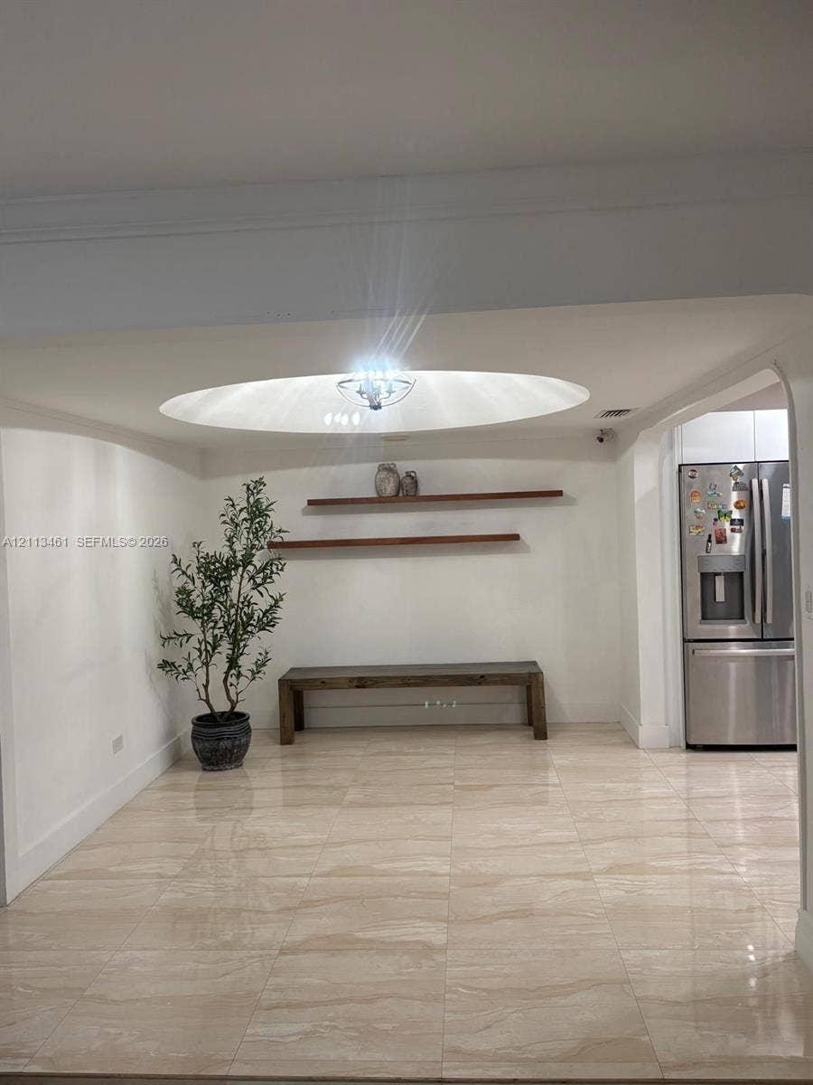 9961 SW 20th Street, Miami, Miami, FL 33165 Large-format tile flooring, recessed circular ceiling feature, flush-mount chandelier, and dual wall-mounted floating wood shelves