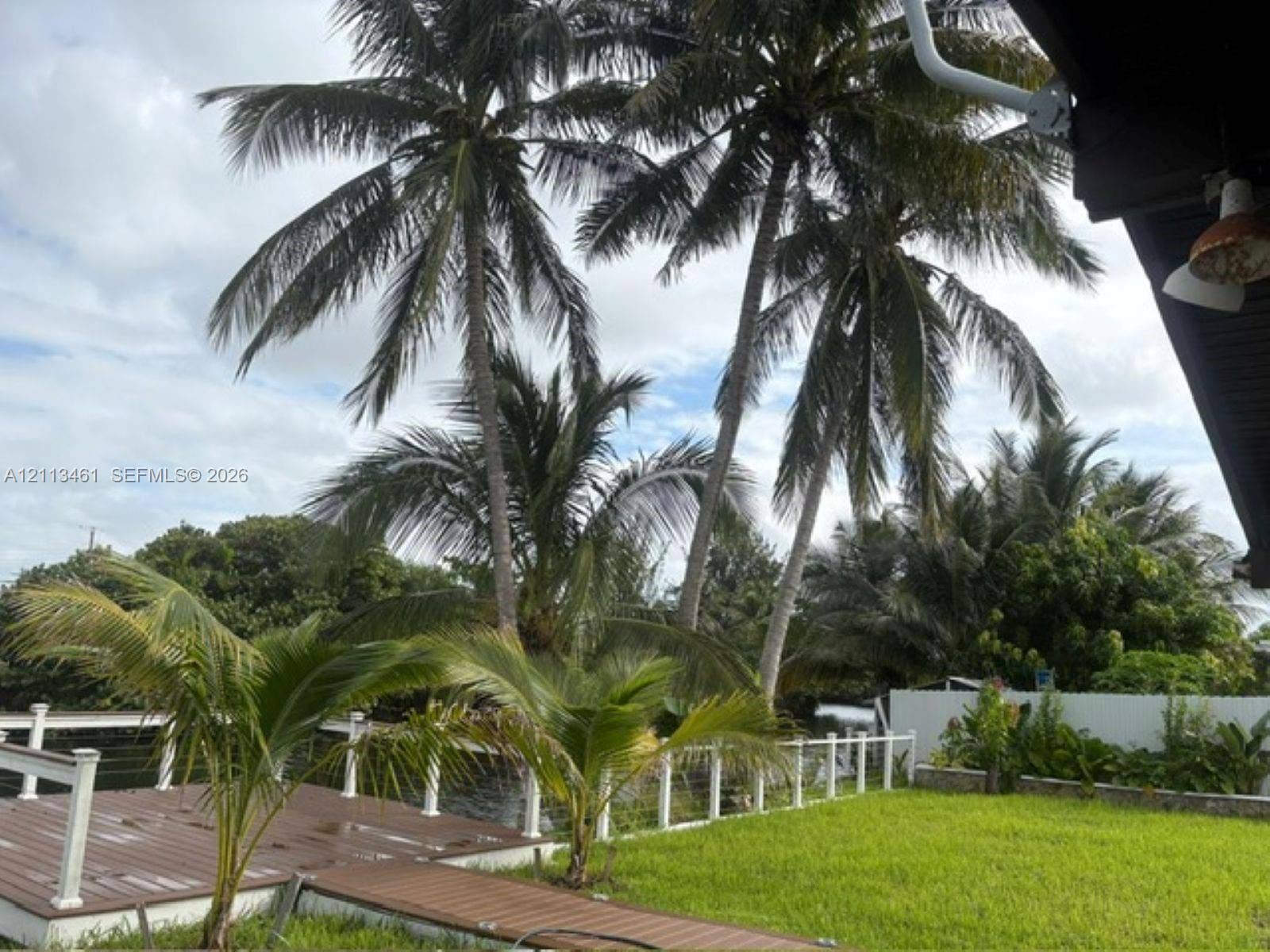 9961 SW 20th Street, Miami, Miami, FL 33165 Outdoor deck with integrated railing, manicured lawn, and mature palm trees
