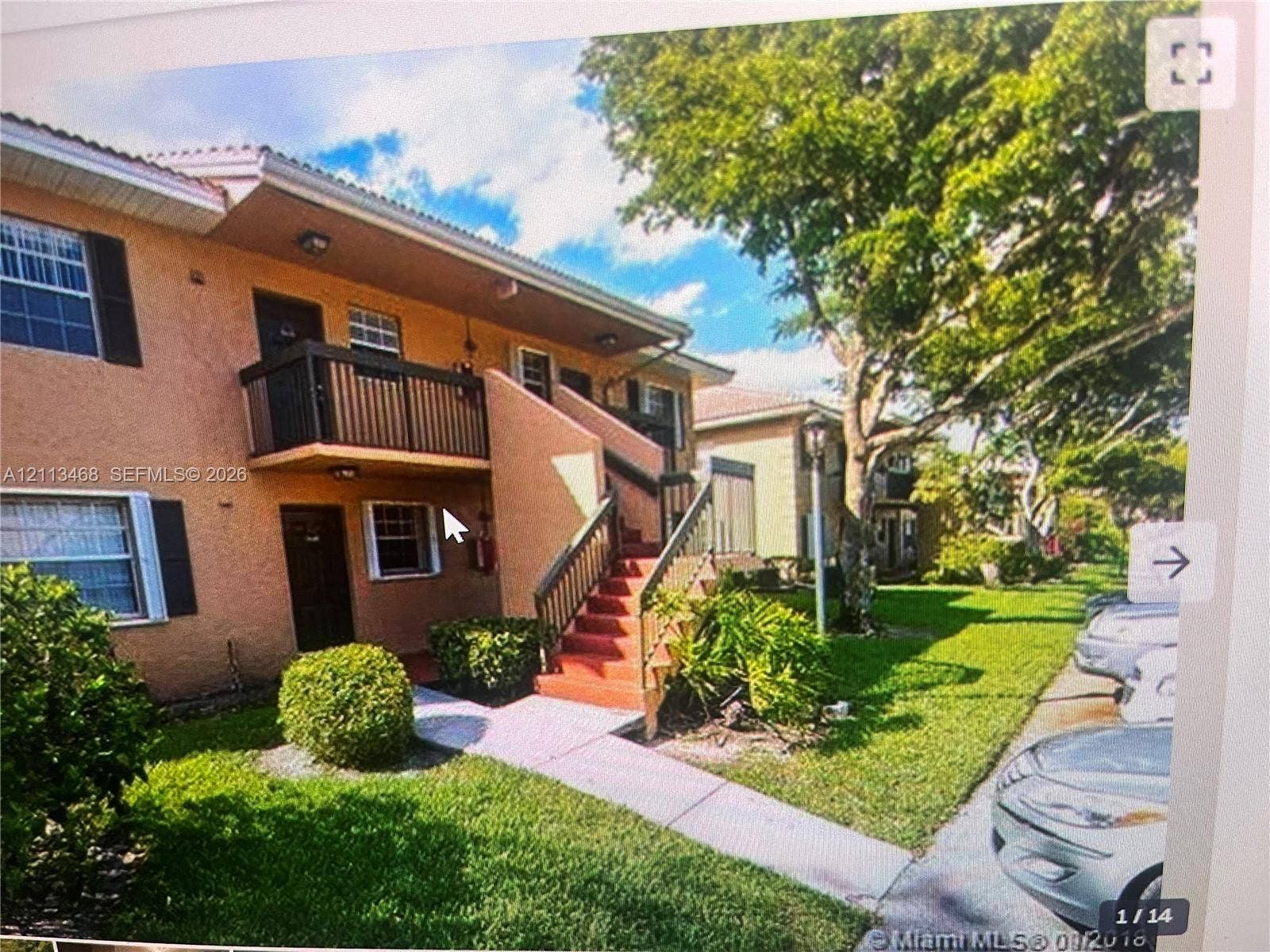 Pembroke Pines, FL 33026 Two-story stucco exterior featuring a private second-level balcony with metal railings and an exterior staircase