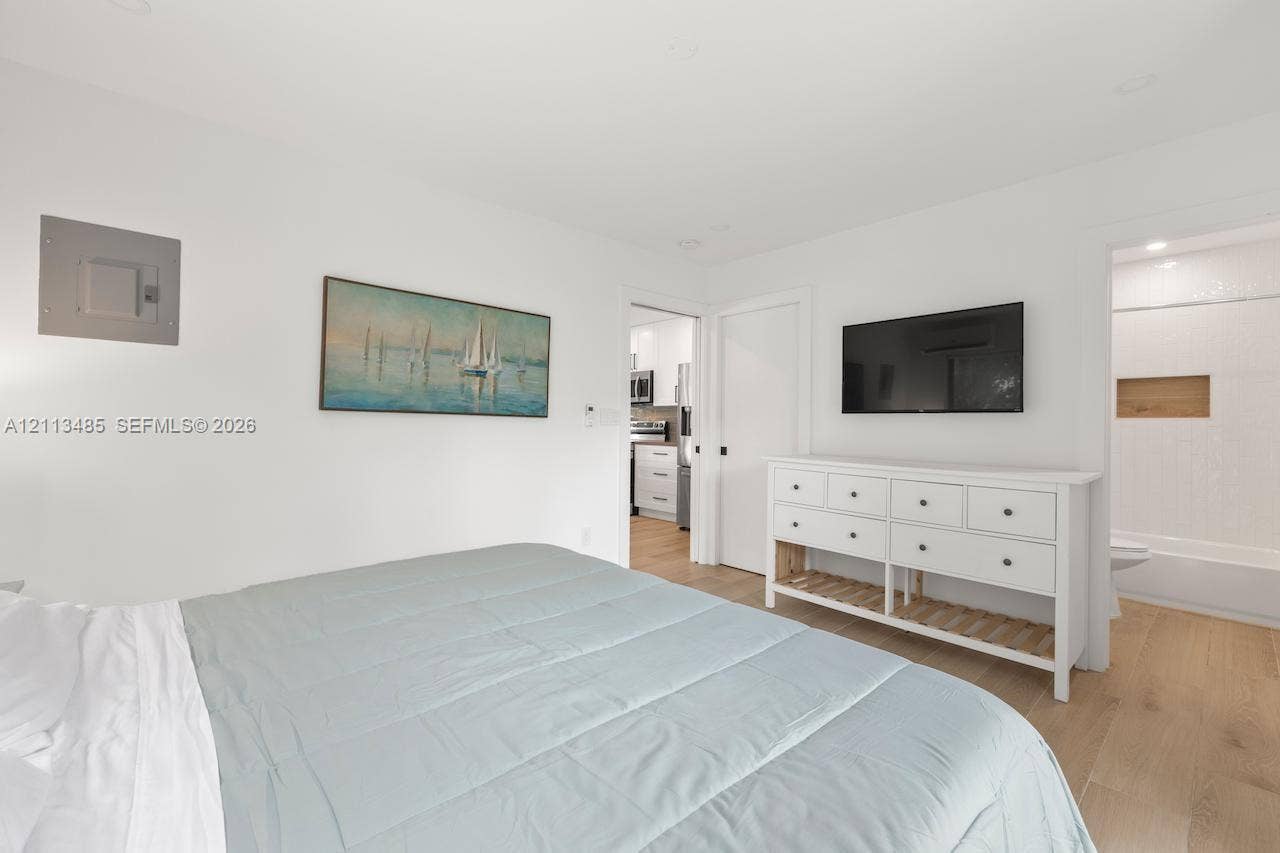 1505 SW 32nd Court, #1, Fort Lauderdale, Fort Lauderdale, FL 33315 Interior space featuring wood-finish flooring, neutral walls, recessed lighting, and a doorway revealing a tiled shower area with a built-in recessed shelf