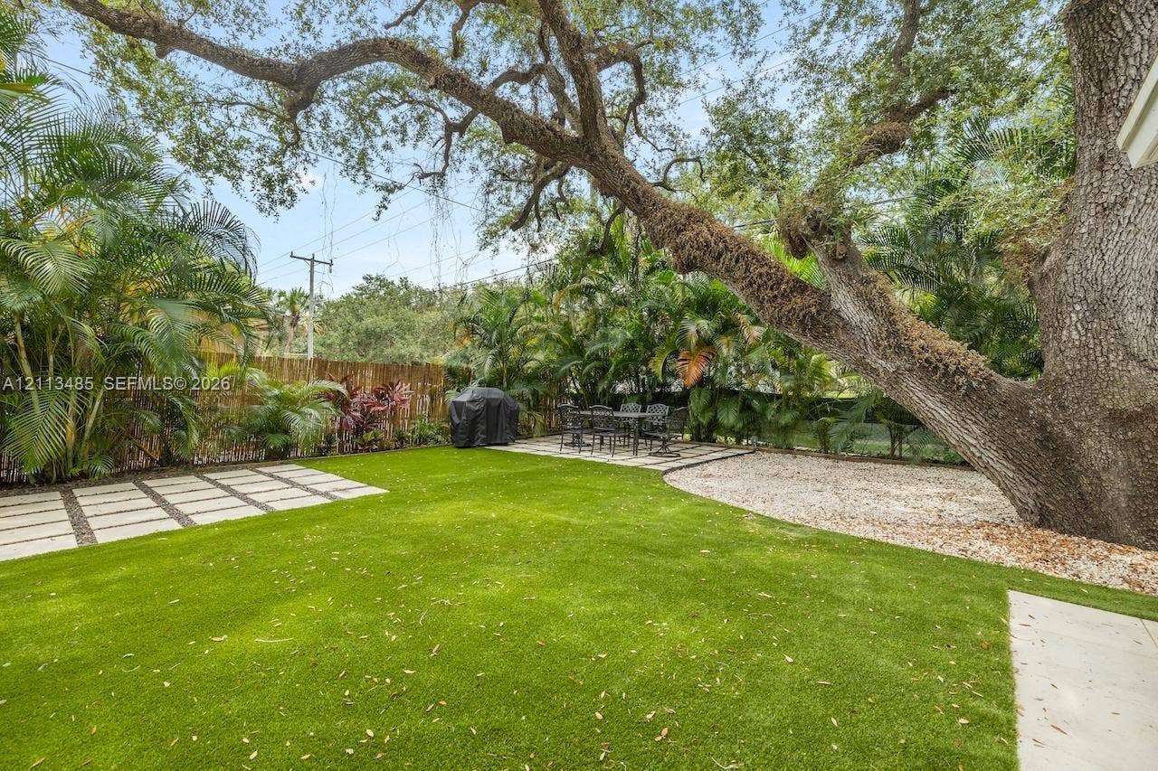 1505 SW 32nd Court, #1, Fort Lauderdale, Fort Lauderdale, FL 33315 Backyard featuring synthetic turf, concrete paver accents, a gravel ground cover area, and mature canopy trees