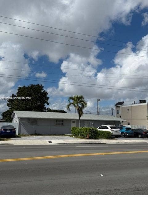 2650 W 8th Avenue, Hialeah, FL 33010 Single-story exterior featuring a concrete driveway, metal window security bars, and a mature palm tree