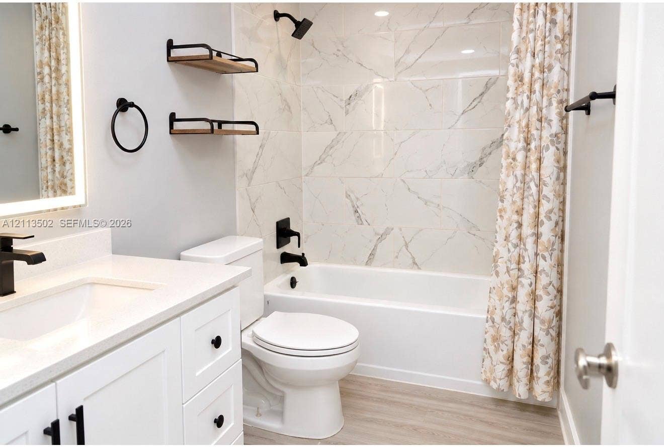 4332 NW 3 Terrace, Deerfield Beach, Deerfield Beach, FL 33064 White vanity with stone-composite countertop, matte black fixtures, built-in floating wall shelves, and floor-to-ceiling tile shower surround