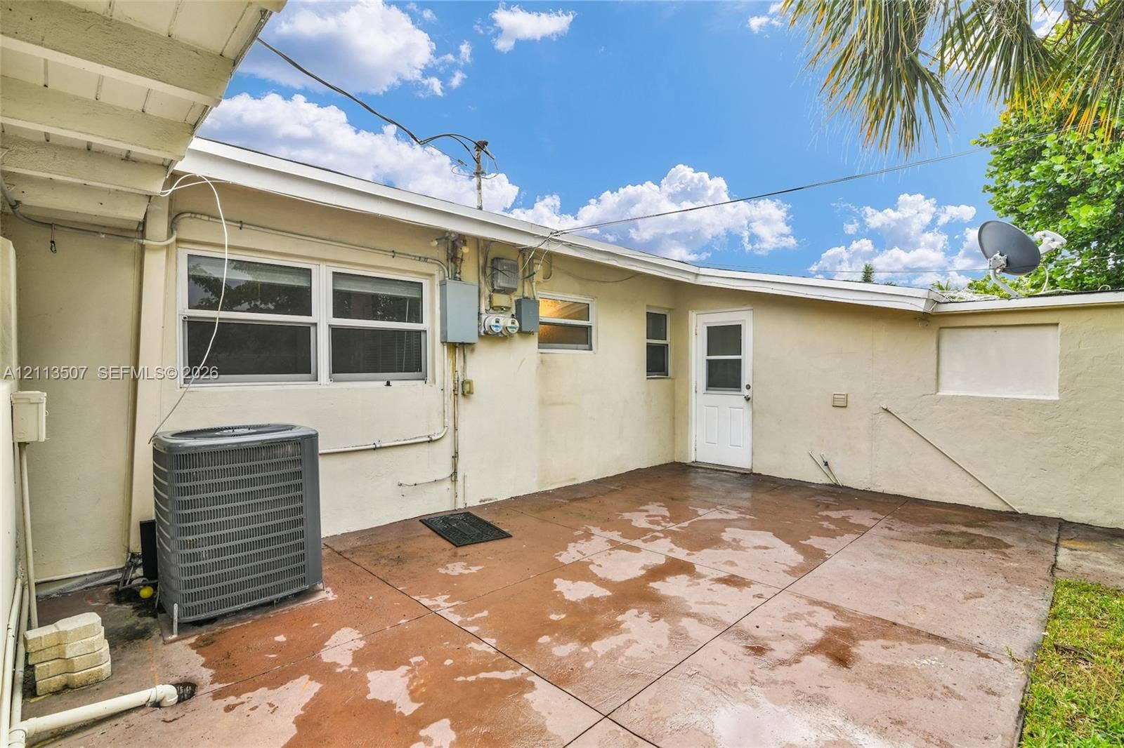 Exterior concrete patio featuring a stucco facade and single-entry door