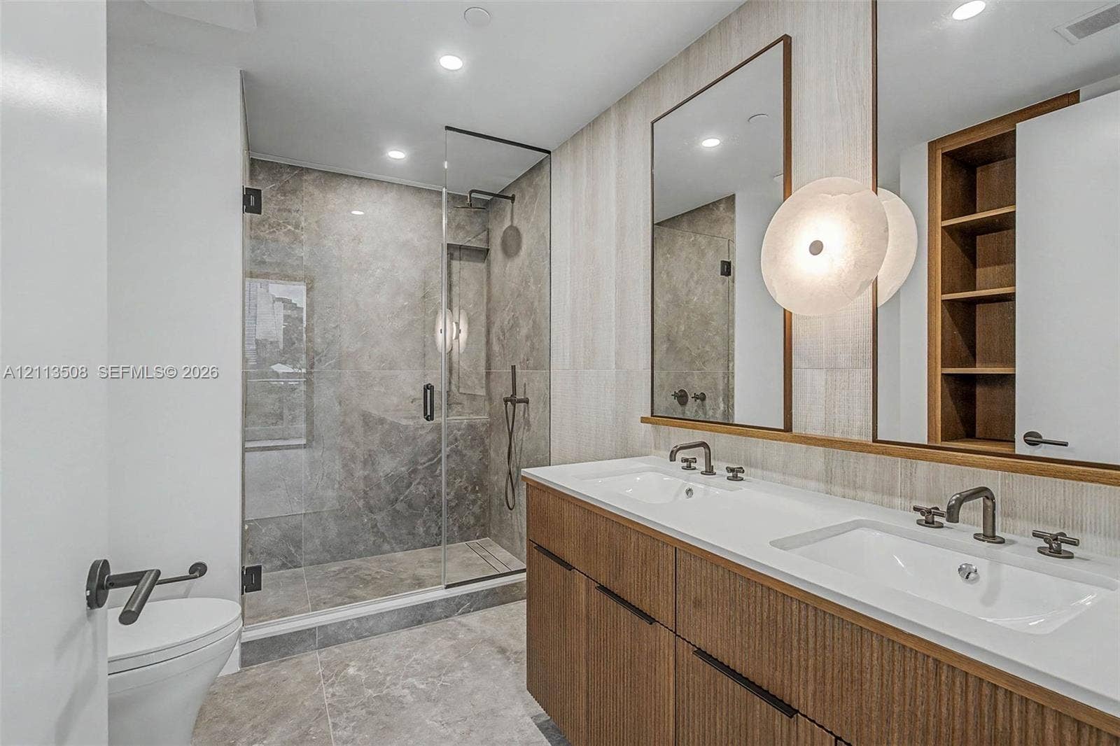 2200 Brickell Avenue, #405, Miami, Miami, FL 33129 Double vanity featuring wood-finish cabinetry, white countertop, integrated sinks, and dual mirrors