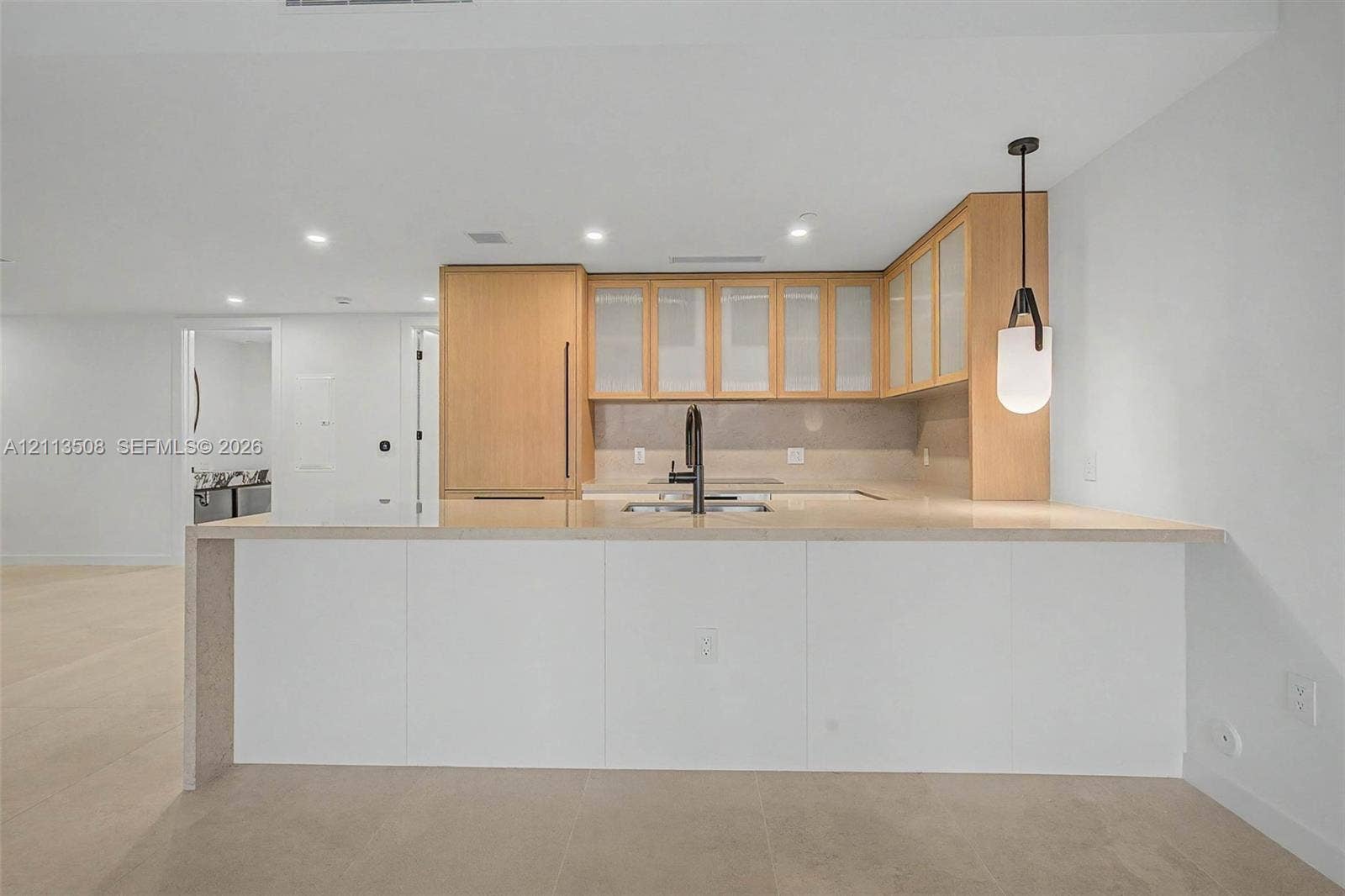 2200 Brickell Avenue, #405, Miami, Miami, FL 33129 Kitchen featuring wood cabinetry with glass-panel upper doors, a stone-finish waterfall edge island, a matte black high-arch faucet, integrated appliances, and recessed ceiling lighting