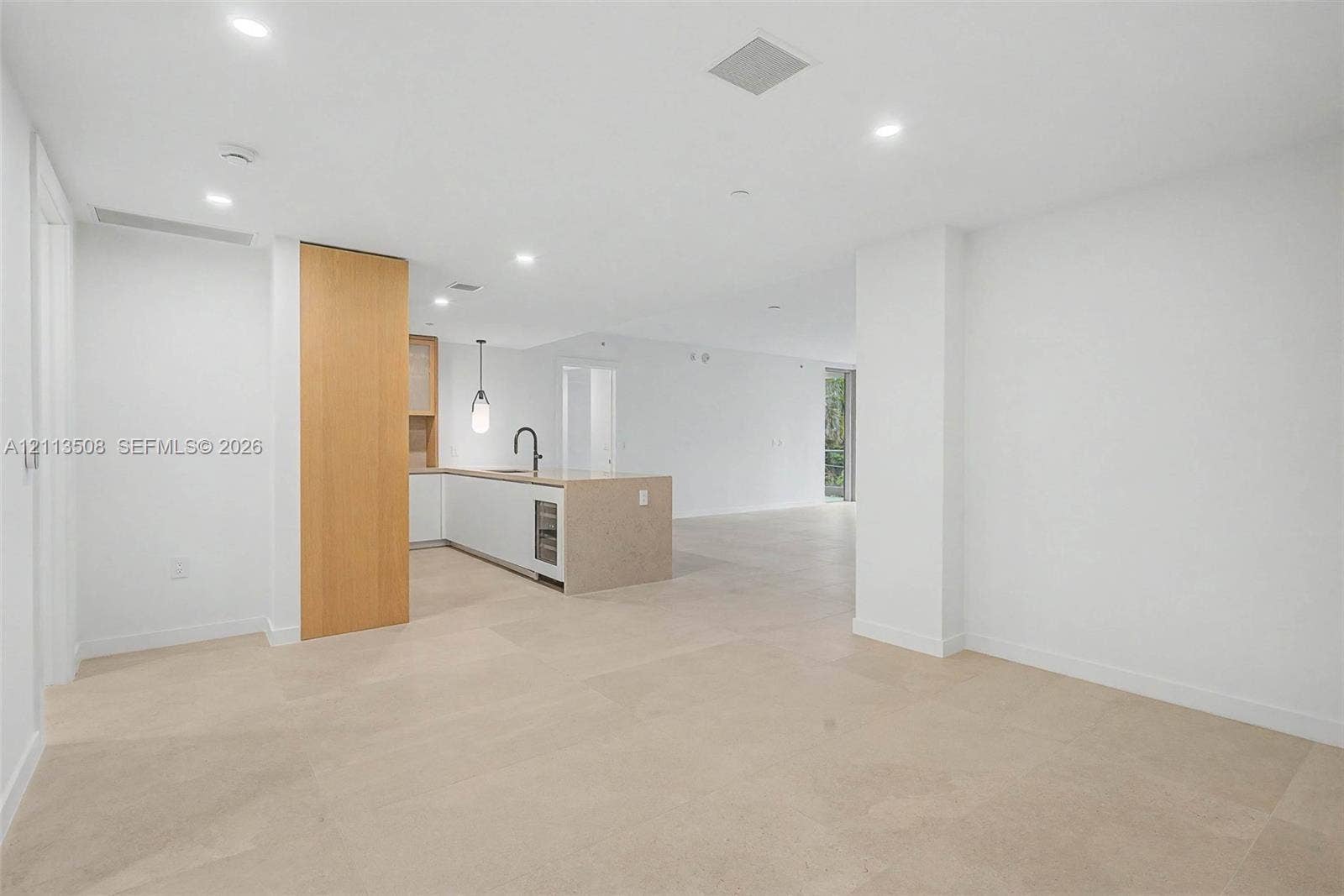2200 Brickell Avenue, #405, Miami, Miami, FL 33129 Open-concept interior featuring large-format tile flooring, recessed ceiling lighting, a kitchen island with a stone-finish countertop, integrated under-counter appliance, and wood-finish cabinetry