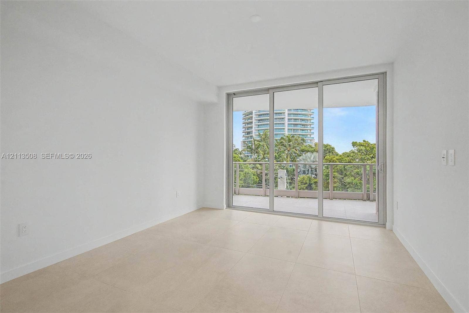 2200 Brickell Avenue, #405, Miami, Miami, FL 33129 Neutral-toned tile flooring, floor-to-ceiling glass sliding doors, and a private balcony with metal railing