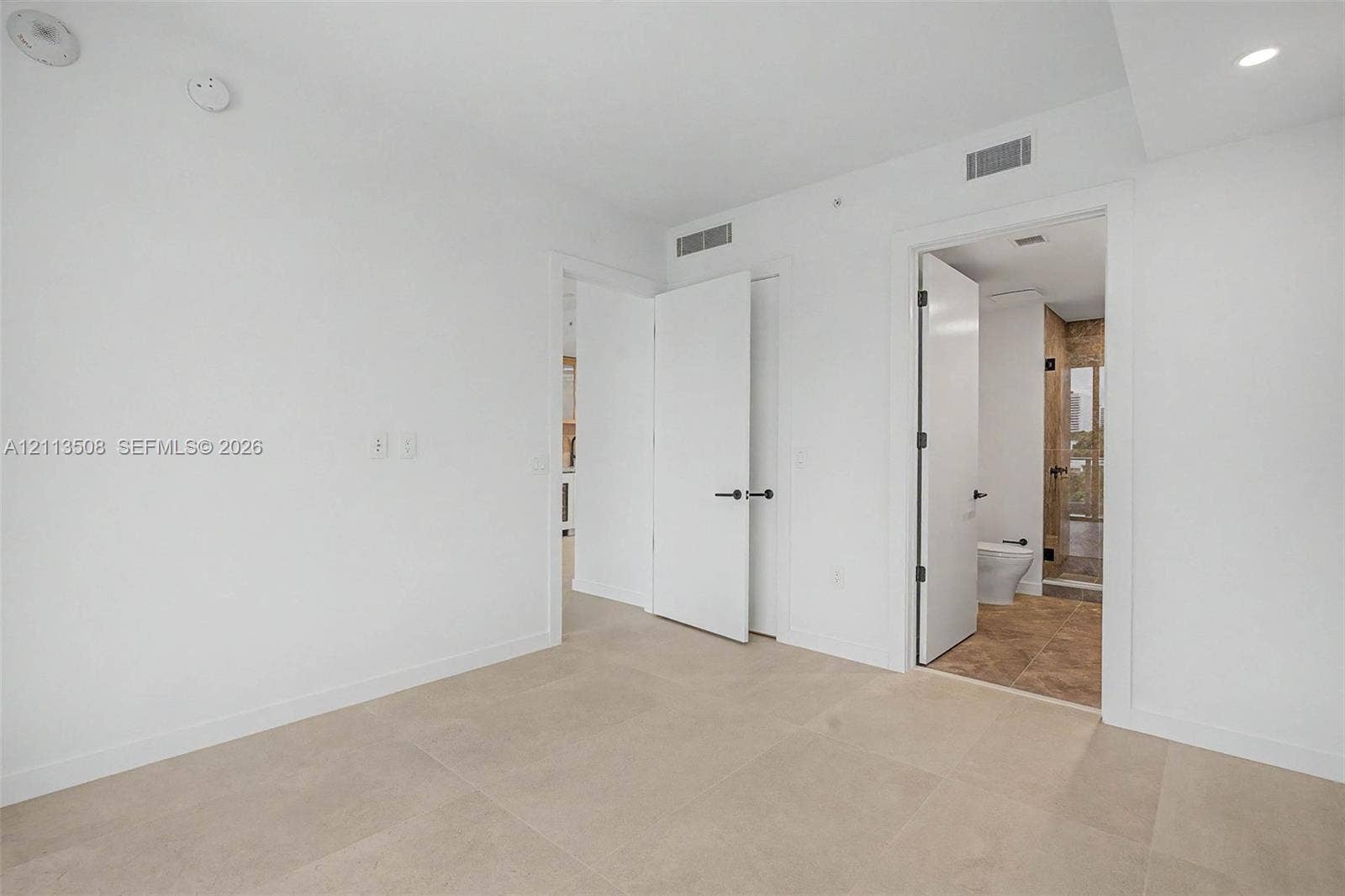 2200 Brickell Avenue, #405, Miami, Miami, FL 33129 Large-format neutral floor tiling, recessed lighting, and solid-core interior doors with matte black hardware