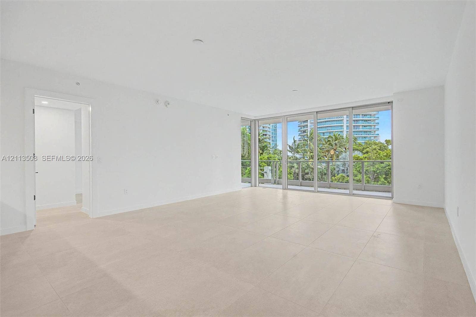 2200 Brickell Avenue, #405, Miami, Miami, FL 33129 Open-concept interior featuring large-format tile flooring, floor-to-ceiling glass sliding doors, and neutral wall finishes