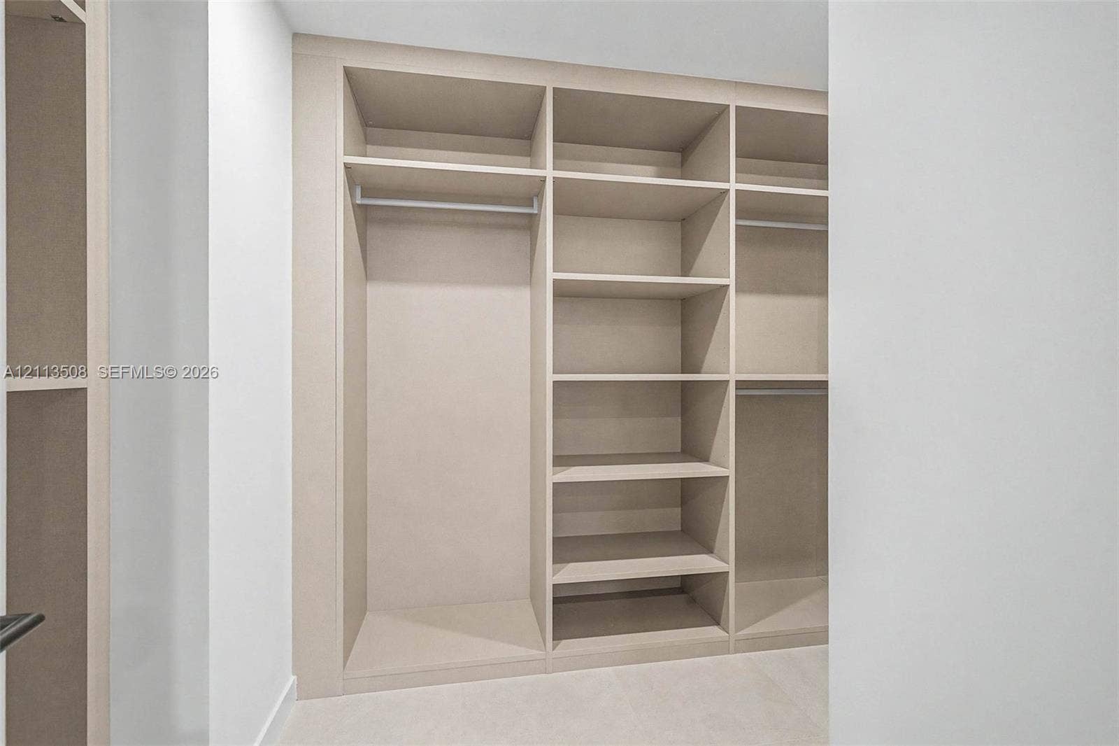 2200 Brickell Avenue, #405, Miami, Miami, FL 33129 Custom built-in storage featuring integrated shelving, vertical partitions, and horizontal hanging rods with a neutral finish