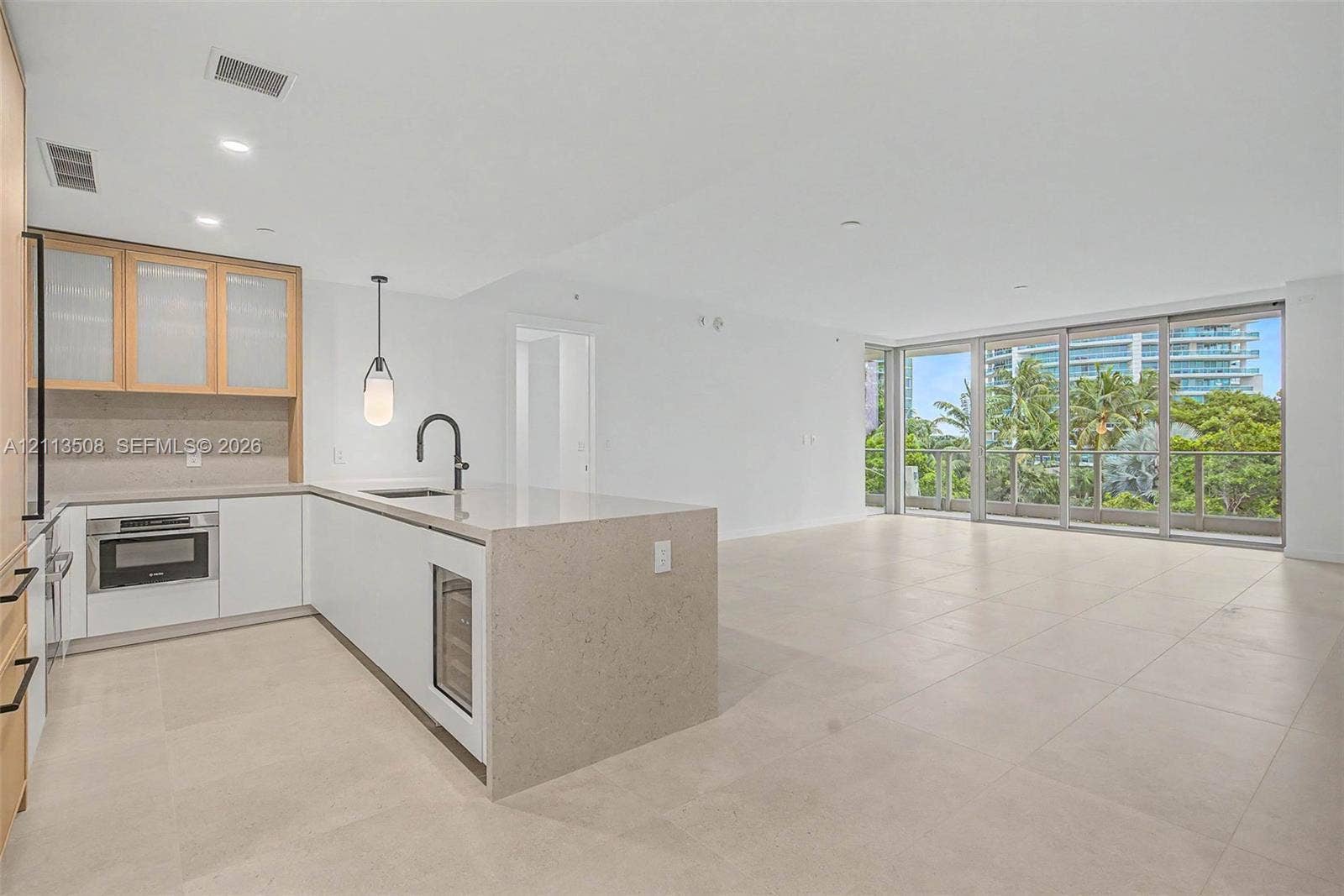 2200 Brickell Avenue, #405, Miami, Miami, FL 33129 Kitchen featuring stone countertops, a waterfall-edge island, built-in beverage refrigerator, matte black faucet, and large-format tile flooring