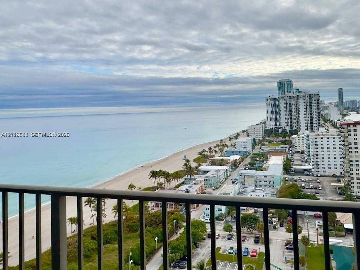 1201 S Ocean Drive, #2202S, Hollywood, FL 33019 Elevated balcony featuring metal railings and a panoramic perspective of the coastline, sandy beach, and ocean