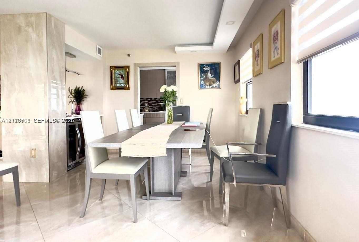 1201 S Ocean Drive, #2202S, Hollywood, FL 33019 Dining area featuring polished stone-finish flooring, a full-height stone-clad column, recessed ceiling lighting, and built-in under-counter beverage refrigeration