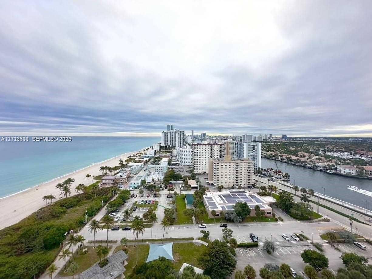 1201 S Ocean Drive, #2202S, Hollywood, FL 33019 Aerial coastal perspective featuring ocean shoreline, sandy beach, integrated waterway, and metropolitan skyline