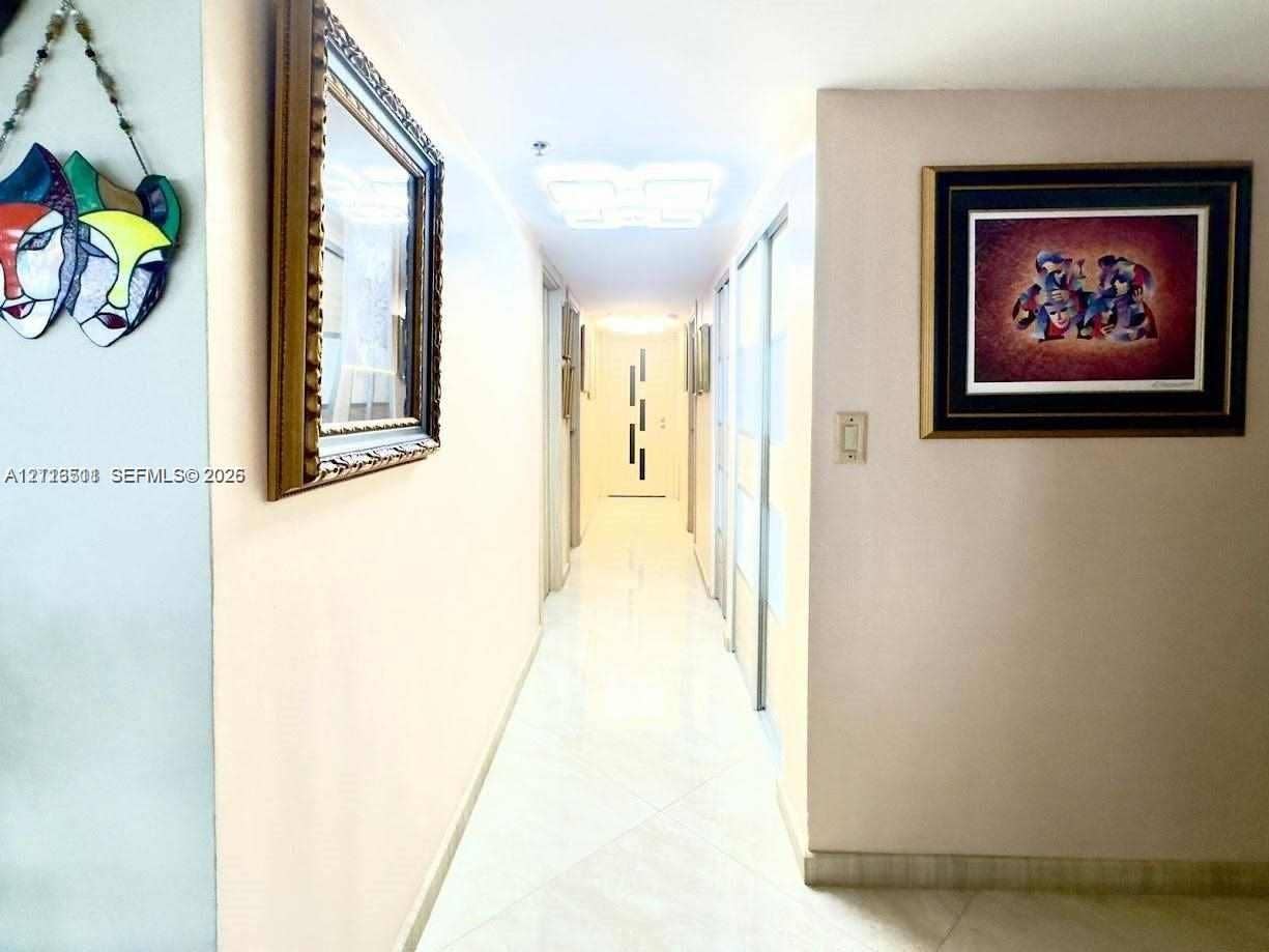 1201 S Ocean Drive, #2202S, Hollywood, FL 33019 Hallway featuring tile flooring, ceiling-mounted light fixtures, and floor-to-ceiling mirrored closet doors