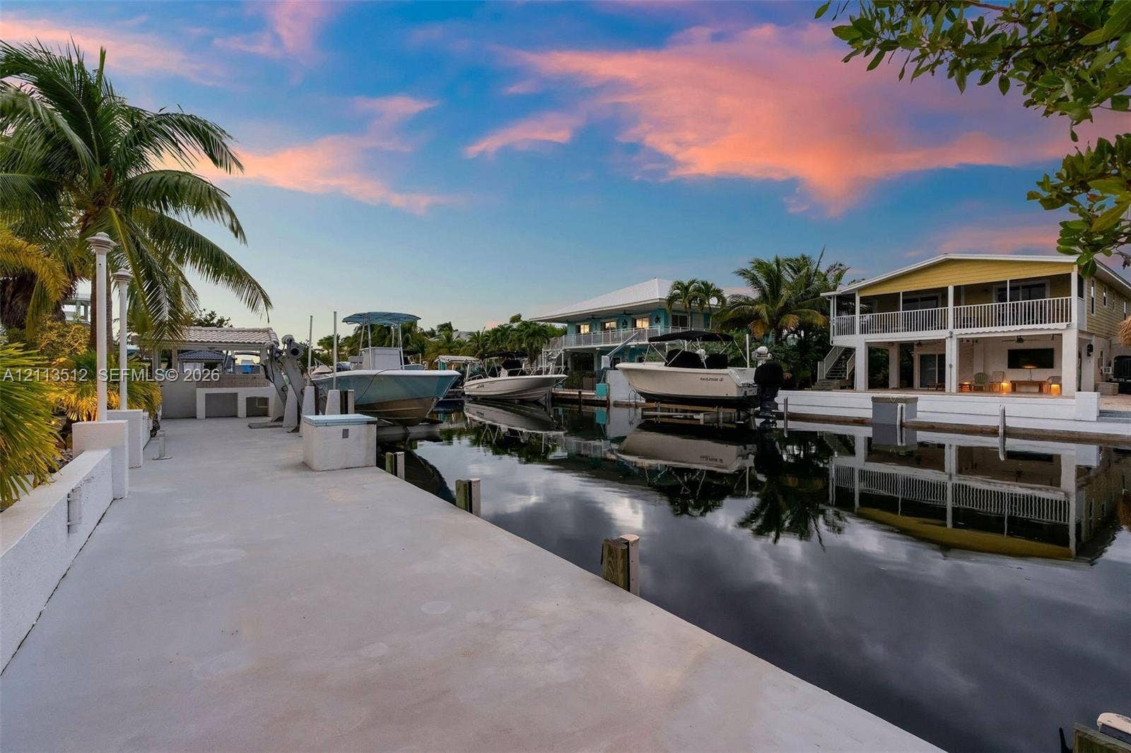 Key Largo, FL 33037 Concrete deep-water dock featuring multiple boat slips, integrated utility pilings, and direct canal access