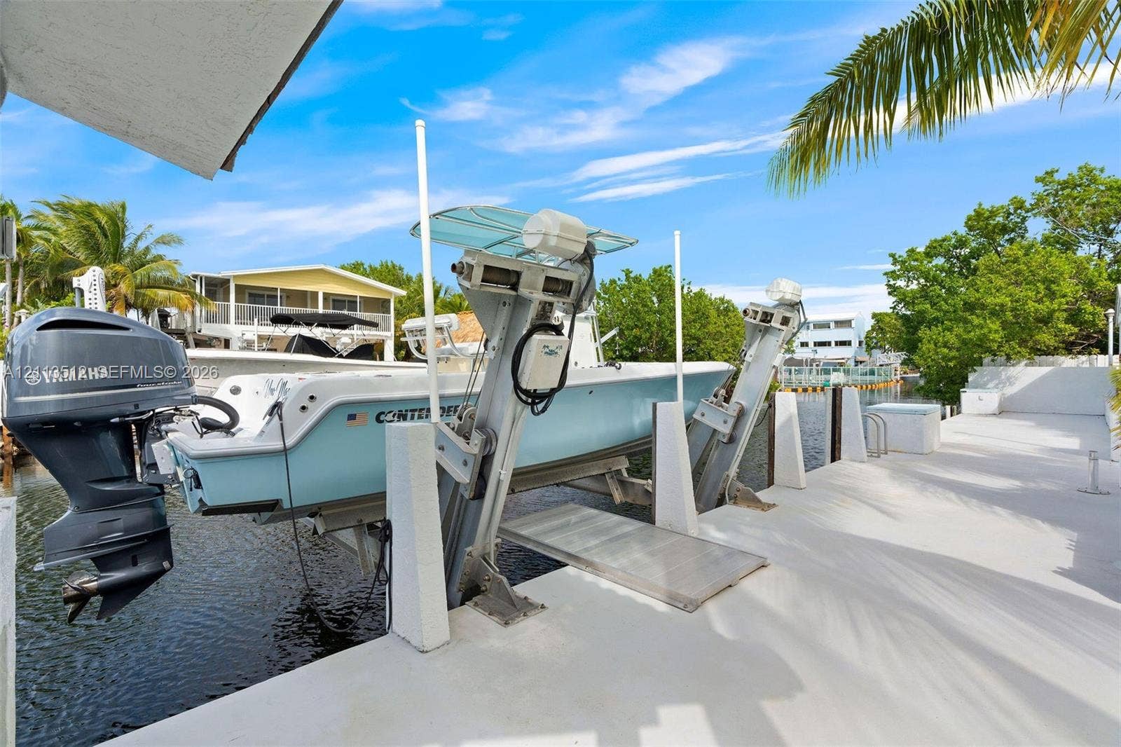 Key Largo, FL 33037 Private boat dock featuring an integrated mechanical boat lift and a paved walkway