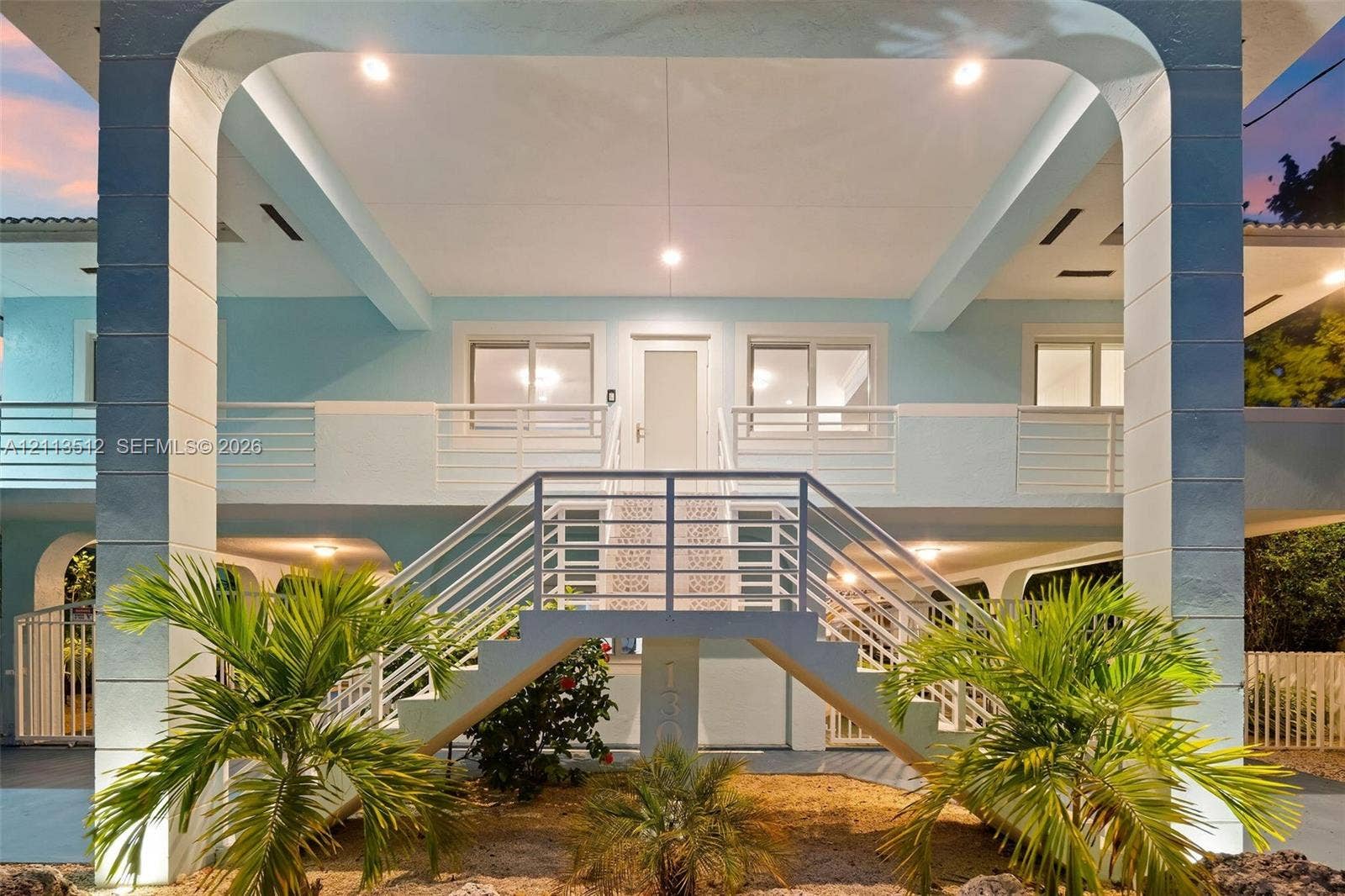 Key Largo, FL 33037 Elevated structure featuring a staircase with metal railings, arched support columns, recessed ceiling lighting, and second-level balcony