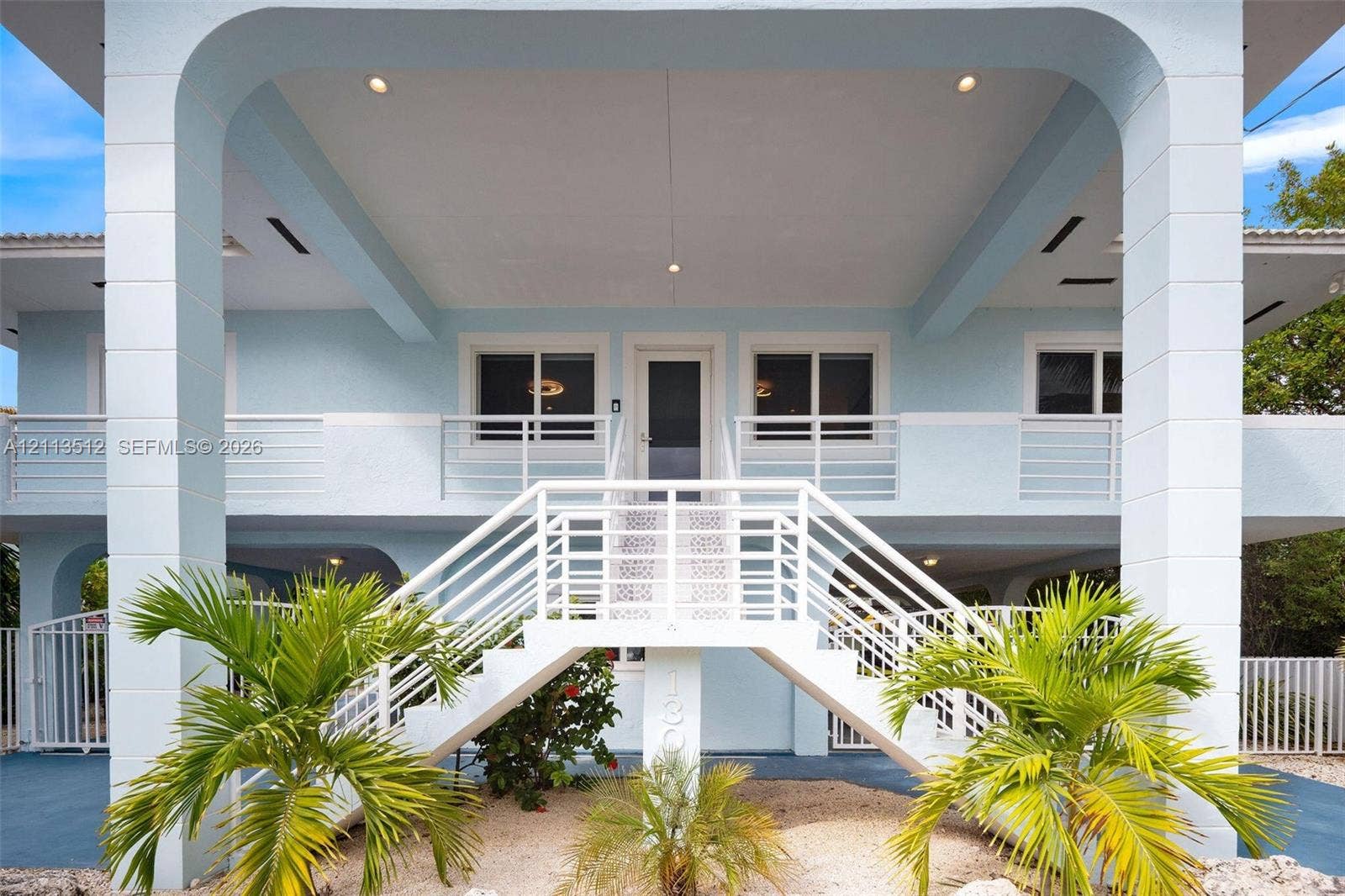 Key Largo, FL 33037 Stilted exterior structure featuring a symmetrical staircase, arched support columns, recessed ceiling lighting, and horizontal metal railing