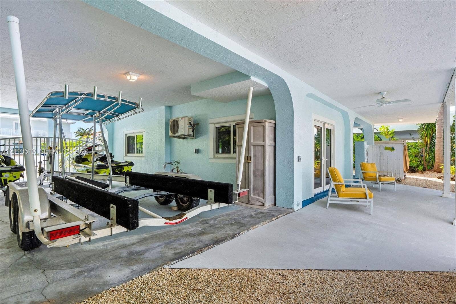 Key Largo, FL 33037 Covered patio featuring concrete flooring, structural arched supports, recessed ceiling lighting, and a built-in exterior storage cabinet