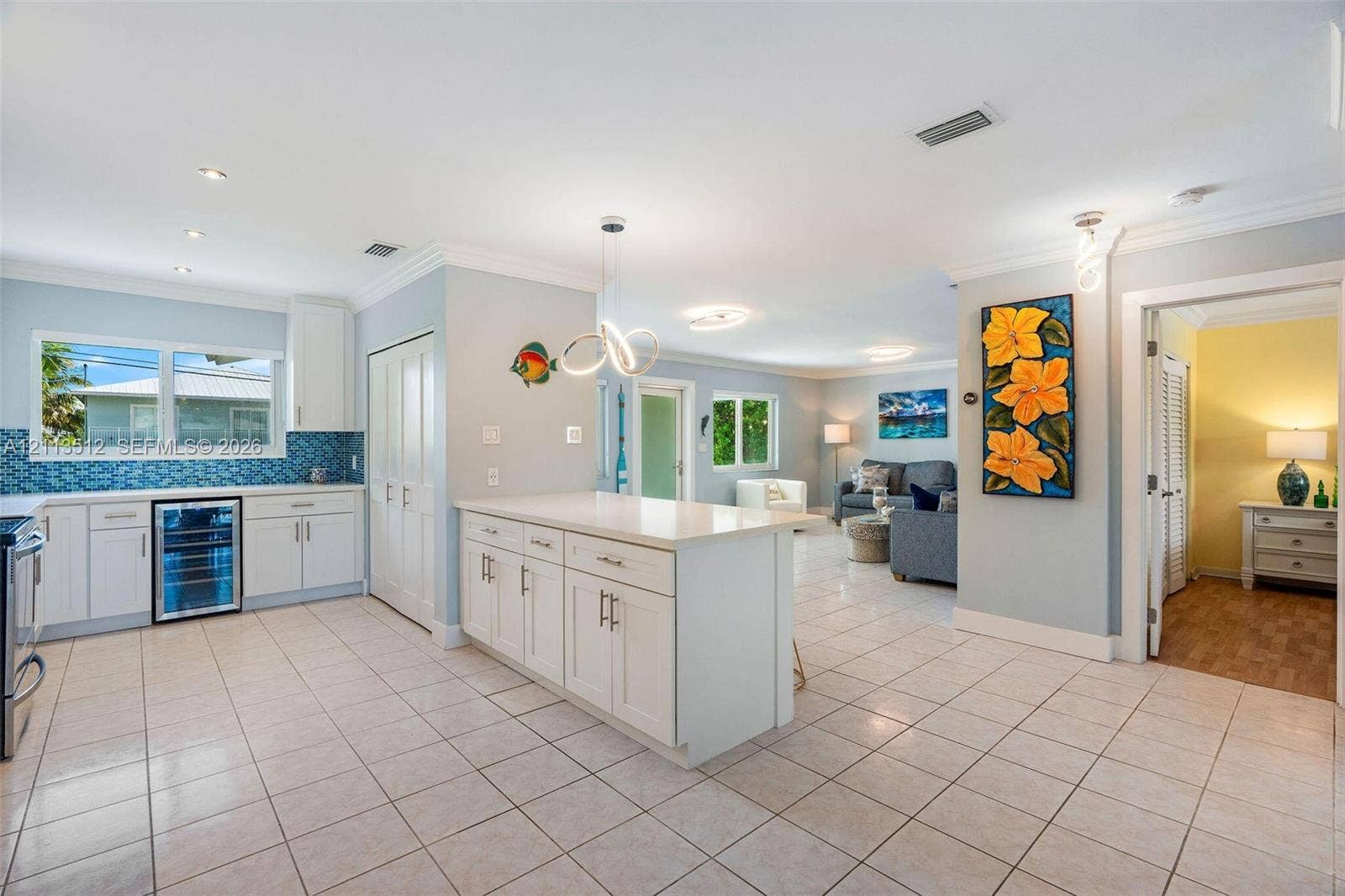 Key Largo, FL 33037 Kitchen featuring white cabinetry, center island with stone countertop, tile backsplash, built-in beverage refrigerator, and tile flooring