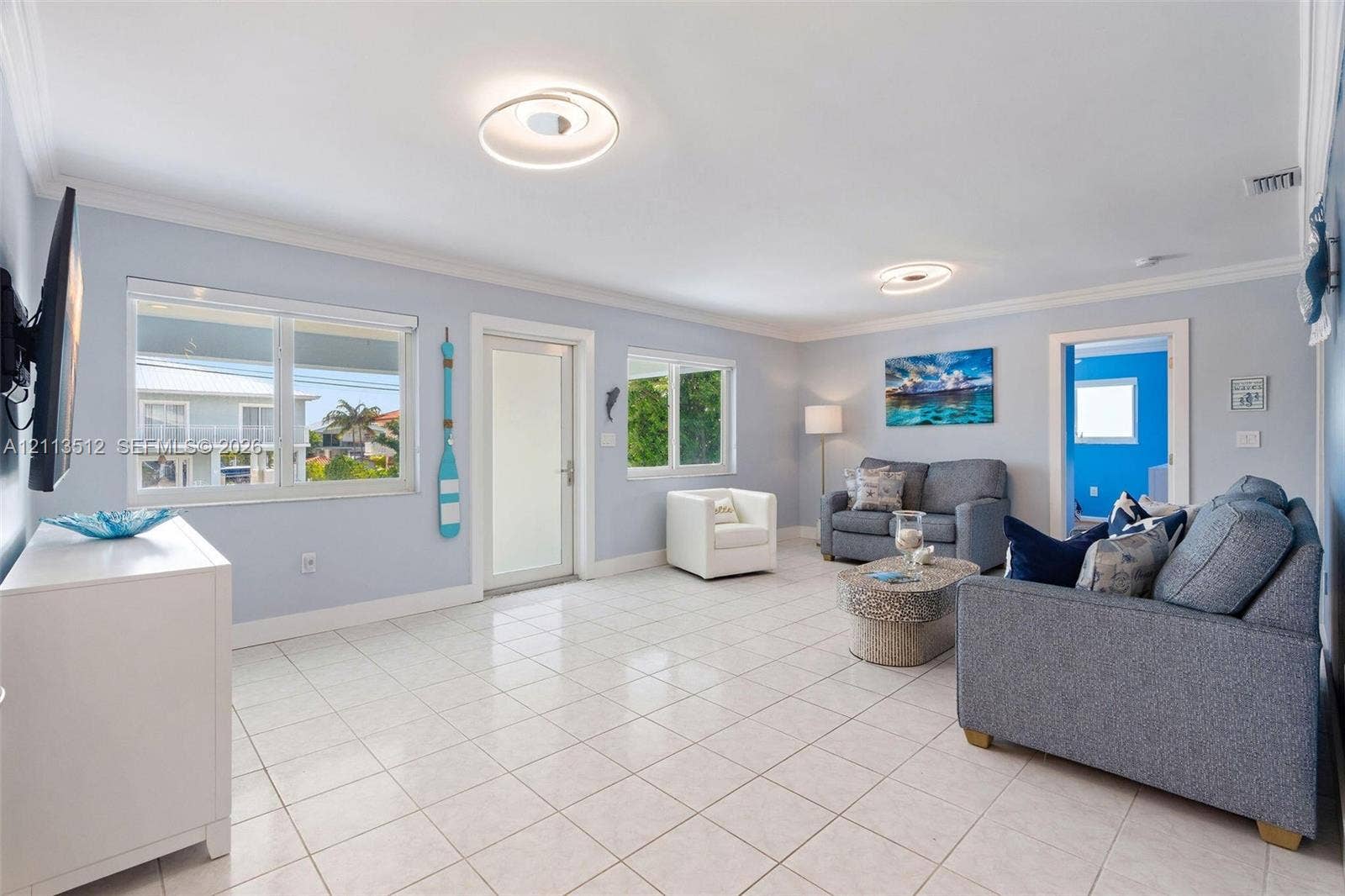 Key Largo, FL 33037 Open-concept room featuring light-toned tile flooring, recessed crown molding, and circular modern flush-mount lighting fixtures