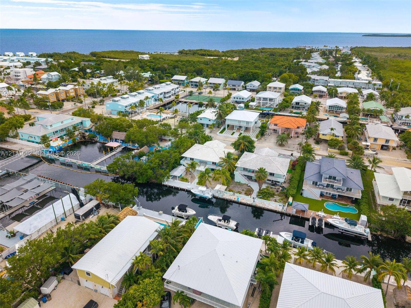 Key Largo, FL 33037 Aerial perspective of waterfront properties featuring deep-water canal access, private boat docks, and established coastal vegetation