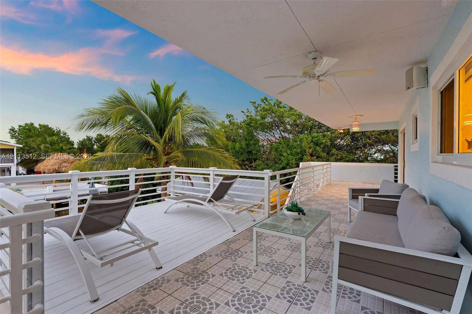 Key Largo, FL 33037 Covered balcony featuring patterned tile flooring, white horizontal railing, and integrated ceiling fans
