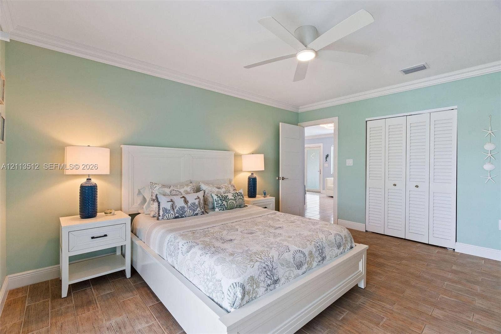 Key Largo, FL 33037 Wood-finish tile flooring, ceiling-mounted light fixture with fan, and closet with white louvered doors